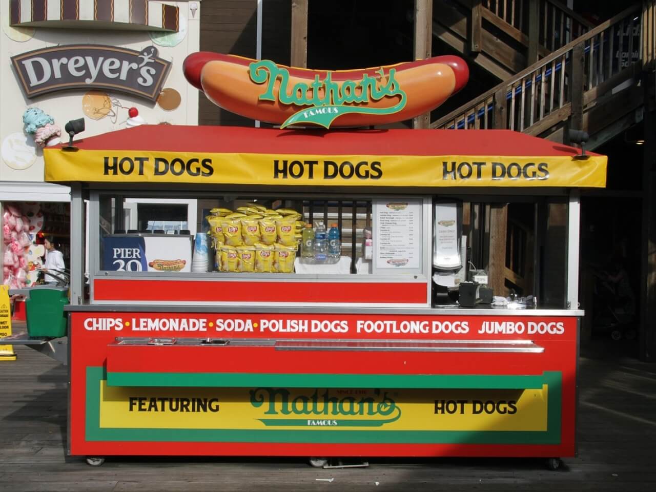 Outdoor food stall counter with overhead signage and front menu board
