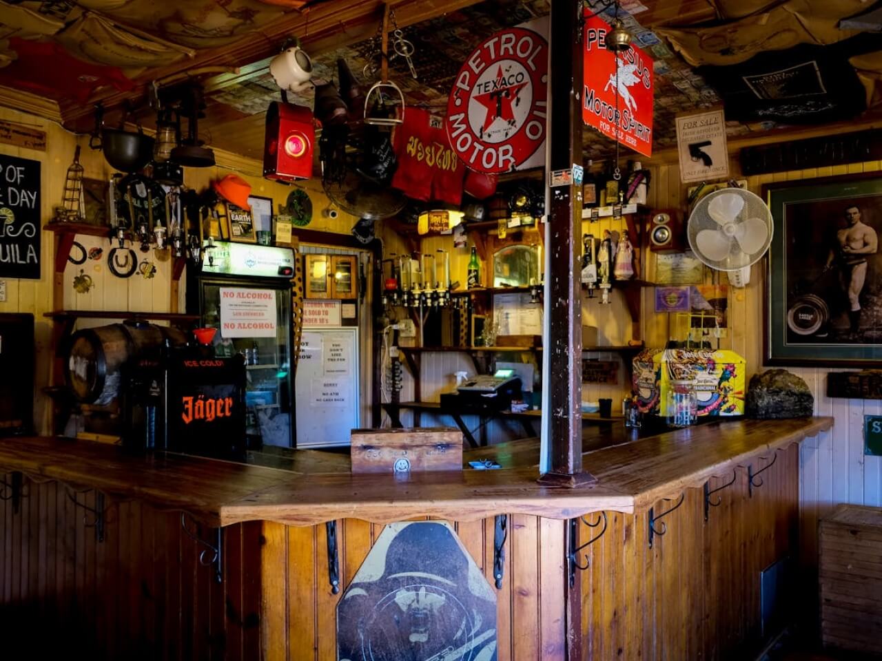 Traditional pub interior with a wooden bar, beer taps, and vintage signs